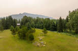Escape to this serene mountain retreat featuring a charming cabin nestled amongst towering evergreen trees.