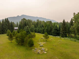 Escape to this serene mountain retreat featuring a charming cabin nestled amongst towering evergreen trees.