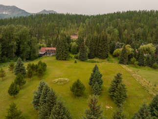 Nestled amidst a lush forest and rolling green hills, this property offers a serene mountain retreat.
