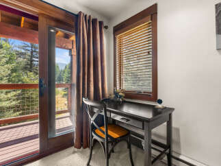 Enjoy stunning mountain views from this charming desk area, complete with a sliding glass door leading to a private balcony.