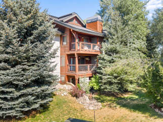 Experience mountain living in this charming wood-accented condo, nestled amongst mature evergreen trees.
