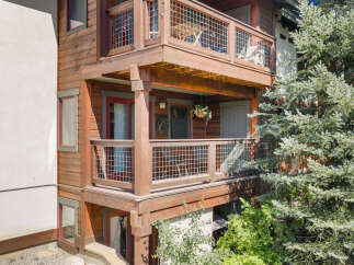 Experience mountain living with this charming wooden home featuring multiple levels of outdoor space.