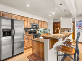 This charming kitchen features beautiful light wood cabinetry and granite countertops, offering a warm and inviting atmosphere.