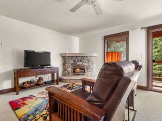 Cozy living room featuring a stone fireplace with a roaring fire, perfect for chilly evenings.