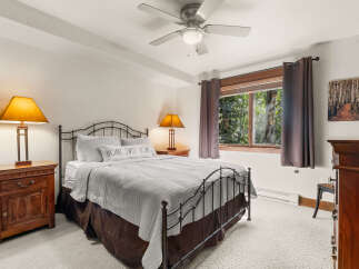 Experience cozy comfort in this charming bedroom, featuring a plush queen-size bed adorned with a 'Home Sweet Home' pillow and a soft, quilted comforter.