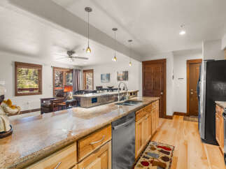 This spacious kitchen boasts granite countertops and ample wooden cabinetry, perfect for storage and meal preparation.