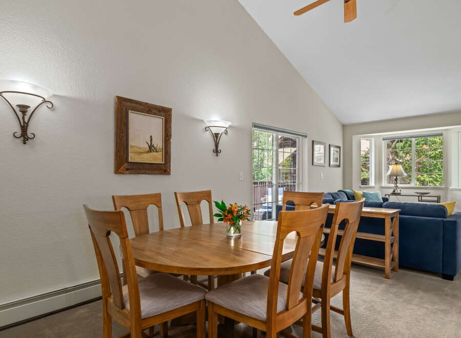 This dining area features a round wooden table with six chairs, perfect for family meals.