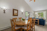 This dining area features a round wooden table with six chairs, perfect for family meals.