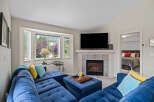 Cozy living room featuring a plush blue sectional sofa and a gas fireplace, perfect for relaxing evenings.