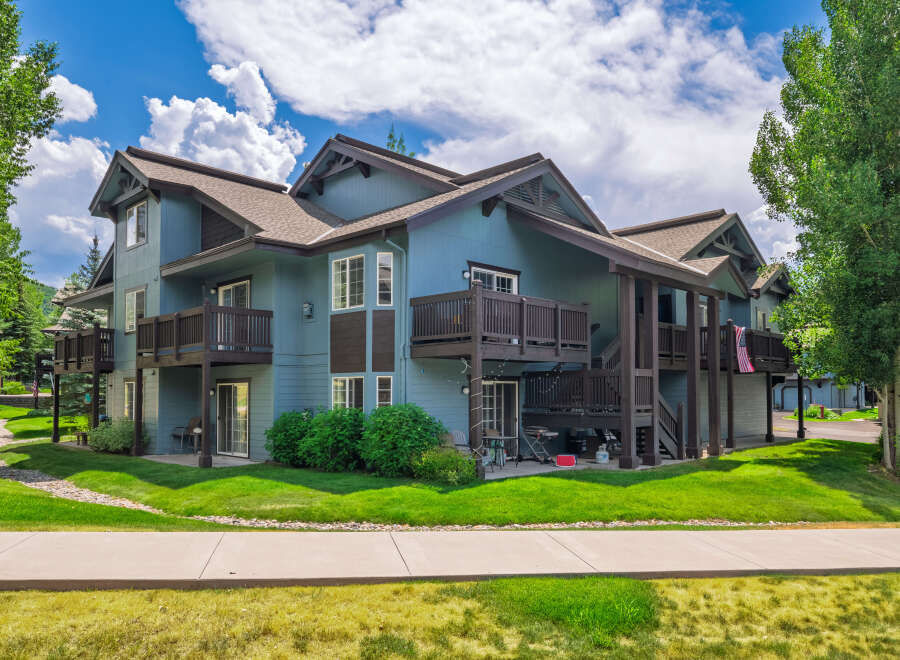 Discover this charming multi-level condo featuring a serene blue exterior and multiple balconies perfect for enjoying the outdoors.
