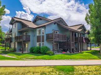 Discover this charming multi-level condo featuring a serene blue exterior and multiple balconies perfect for enjoying the outdoors.