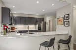 Discover this beautifully updated kitchen featuring sleek dark gray cabinetry and modern quartz countertops.