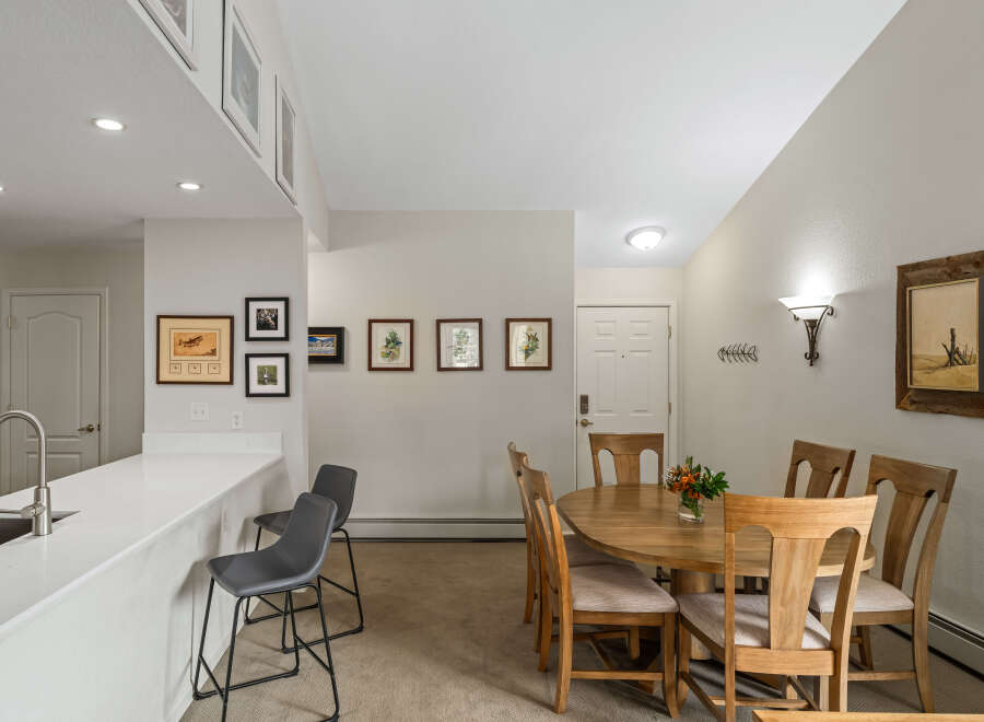 This inviting dining area features a round wooden table with four chairs, perfect for intimate gatherings.