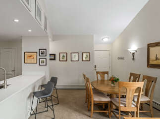 This inviting dining area features a round wooden table with four chairs, perfect for intimate gatherings.