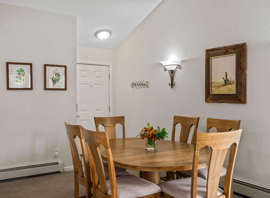 Gather around the elegant wooden dining table, perfect for intimate meals or lively gatherings.