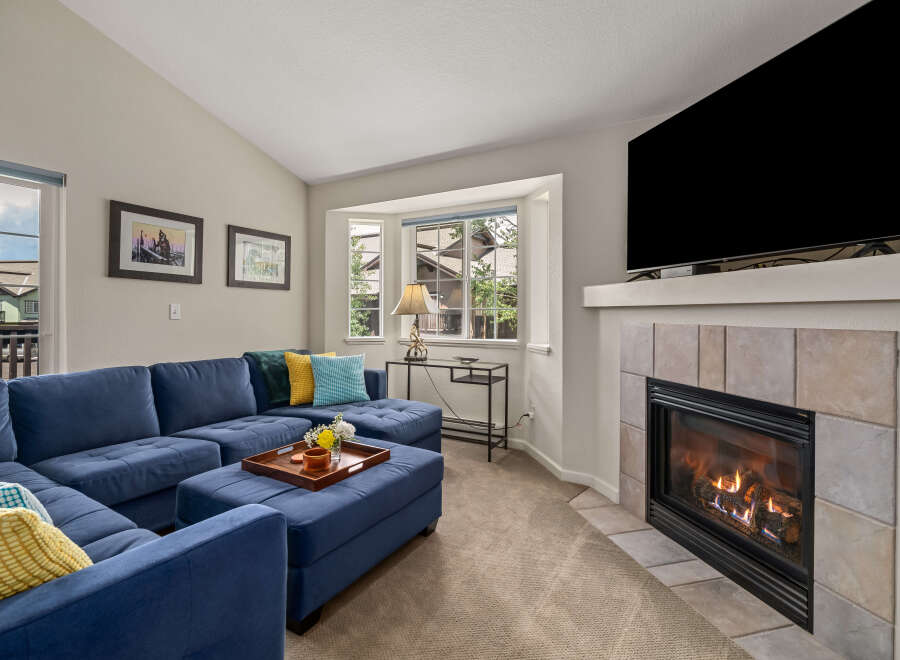 Cozy up by the gas fireplace in this inviting living room, featuring a spacious sectional sofa perfect for family gatherings.