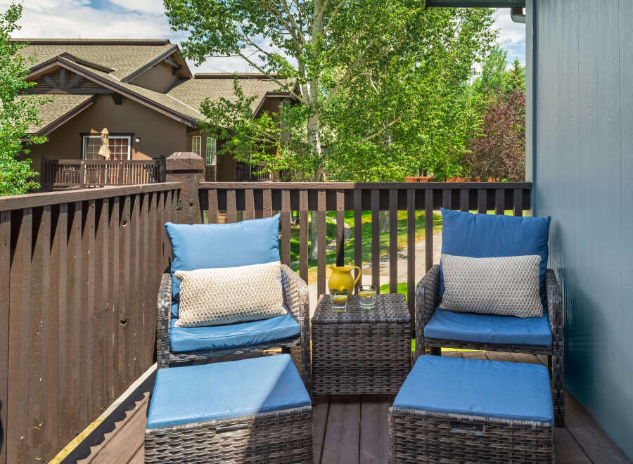 Enjoy your morning coffee or evening relaxation on this charming balcony, complete with comfortable seating and ottomans.