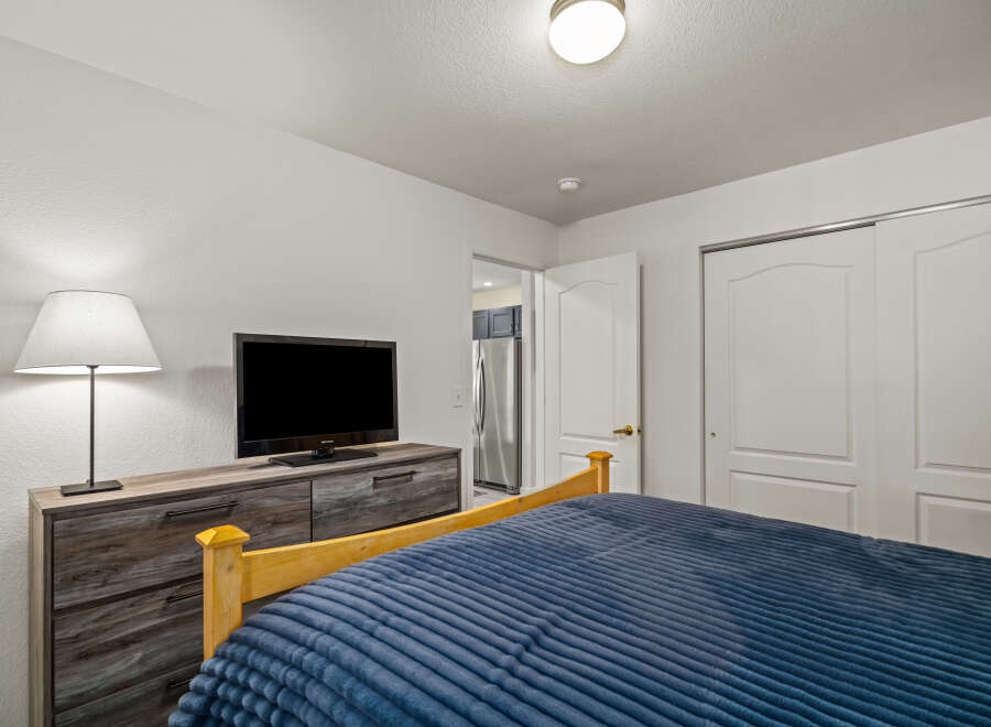 This cozy bedroom features a comfortable bed with a plush blue comforter, perfect for relaxing.