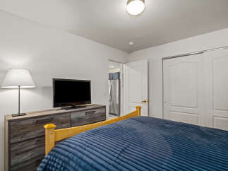 This cozy bedroom features a comfortable bed with a plush blue comforter, perfect for relaxing.