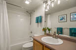 This bathroom features a clean and bright aesthetic with white tiled walls and a classic white bathtub.