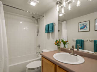 This bathroom features a clean and bright aesthetic with white tiled walls and a classic white bathtub.