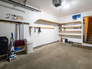 This garage offers ample storage with multiple shelves and a wall-mounted rack system, perfect for organizing tools and equipment.