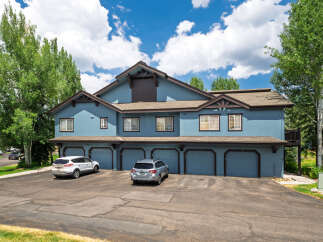 Discover this charming multi-unit property featuring a striking blue exterior and multiple garage doors, perfect for a rental portfolio or a spacious residence.