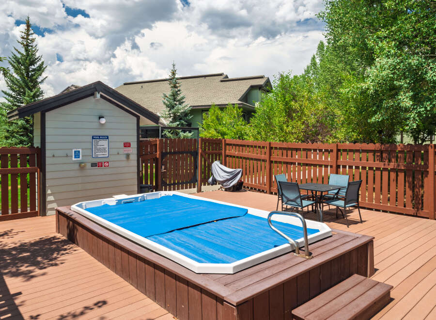 Enjoy outdoor living with this spacious deck featuring a covered hot tub, perfect for relaxation.