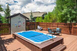 Enjoy outdoor living with this spacious deck featuring a covered hot tub, perfect for relaxation.