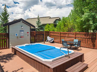 Enjoy outdoor living with this spacious deck featuring a covered hot tub, perfect for relaxation.