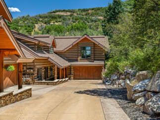 Experience rustic charm in this stunning log home nestled against a scenic hillside.
