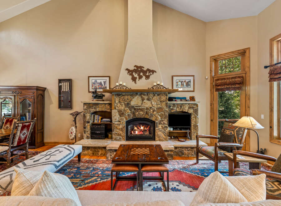 Experience rustic elegance in this stunning living room, featuring a grand stone fireplace as the centerpiece, perfect for cozy evenings.