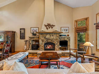 Experience rustic elegance in this stunning living room, featuring a grand stone fireplace as the centerpiece, perfect for cozy evenings.