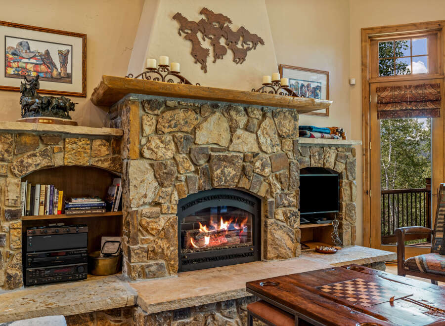 Cozy up by the stunning stone fireplace, a true centerpiece of this inviting living space.