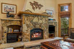 Cozy up by the stunning stone fireplace, a true centerpiece of this inviting living space.