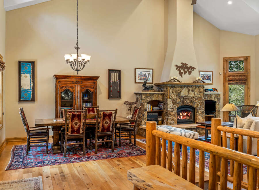 Experience rustic elegance in this spacious living and dining area, featuring a grand stone fireplace as the centerpiece.
