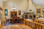 Experience rustic elegance in this spacious living and dining area, featuring a grand stone fireplace as the centerpiece.