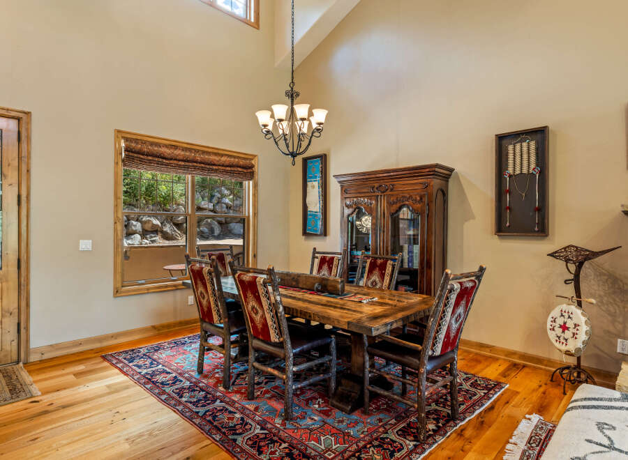 Experience rustic charm in this inviting dining room, featuring a substantial wooden table with uniquely crafted chairs upholstered in a striking Native American-inspired pattern.