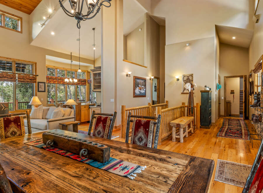 Experience rustic elegance in this spacious dining and living area, featuring a grand wooden dining table perfect for gatherings.