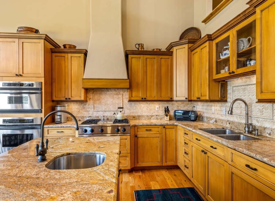 Experience culinary excellence in this stunning kitchen, featuring custom wood cabinetry and granite countertops.