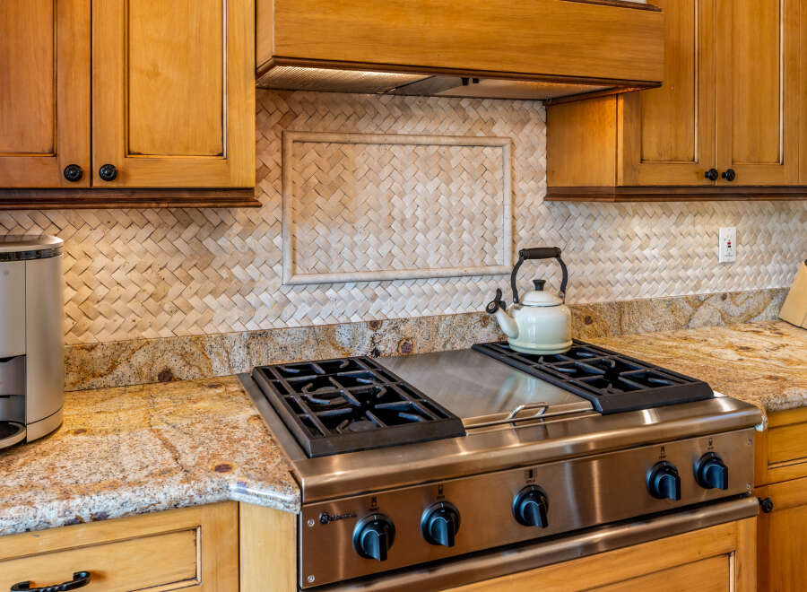 This kitchen features warm, honey-toned wood cabinetry complemented by a striking granite countertop.