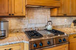 This kitchen features warm, honey-toned wood cabinetry complemented by a striking granite countertop.