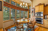 Enjoy breathtaking forest views from this charming dining area, featuring a round wooden table and comfortable chairs perfect for intimate gatherings.