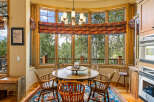Enjoy breathtaking mountain views from this charming dining nook, featuring a round wooden table surrounded by classic Windsor chairs.