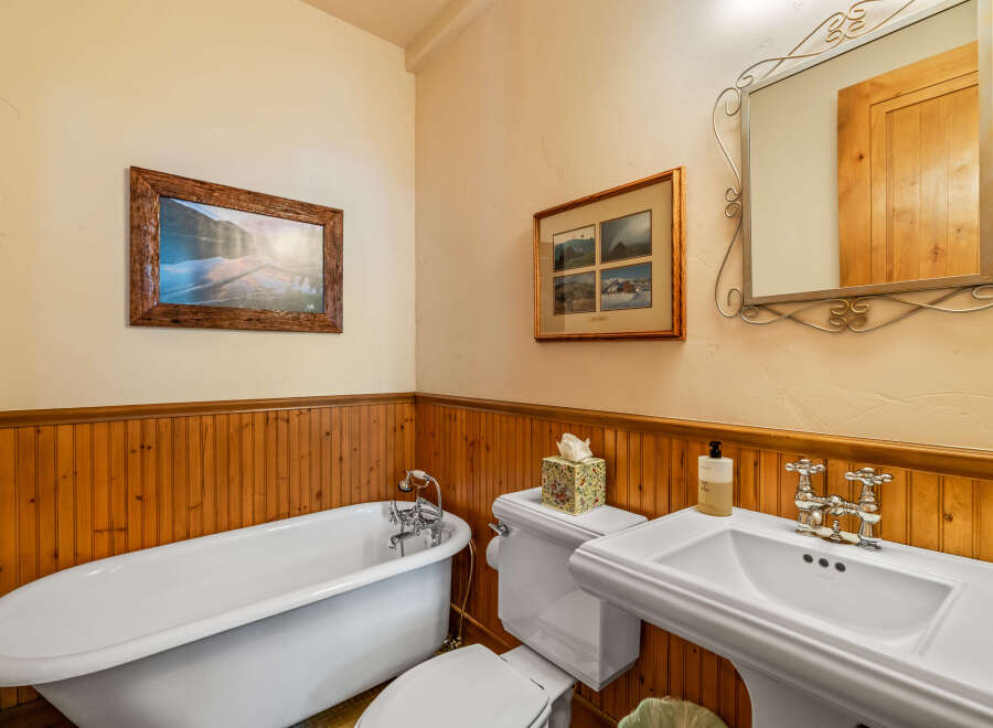 This charming bathroom features a classic clawfoot bathtub, perfect for a relaxing soak.