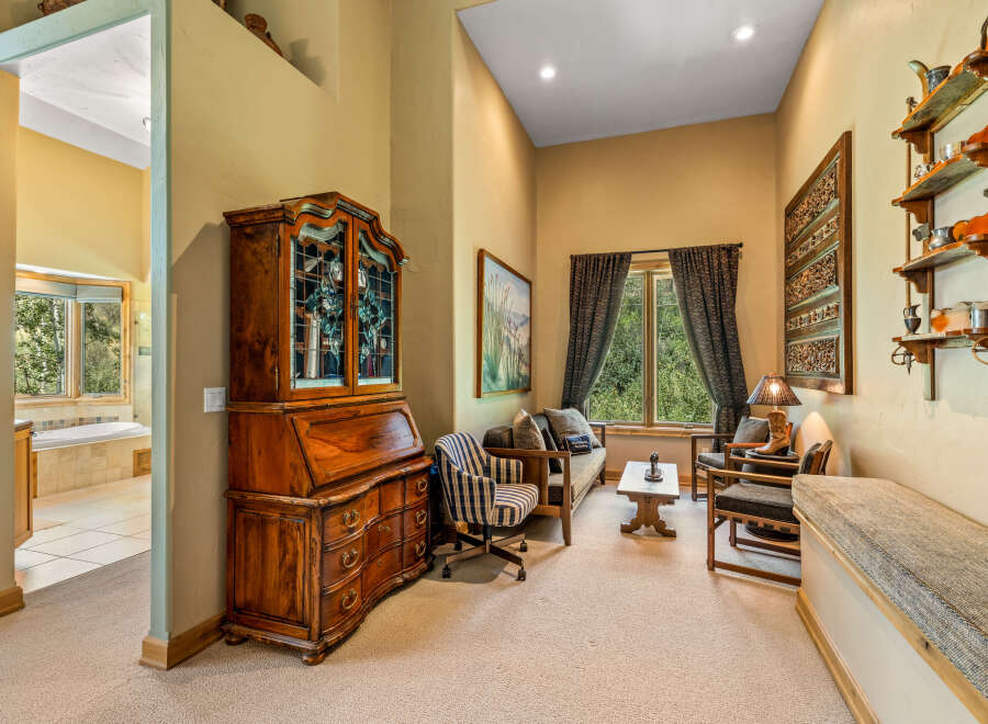 Step into this charming living area, featuring a beautiful antique secretary desk and a cozy seating arrangement perfect for relaxation.