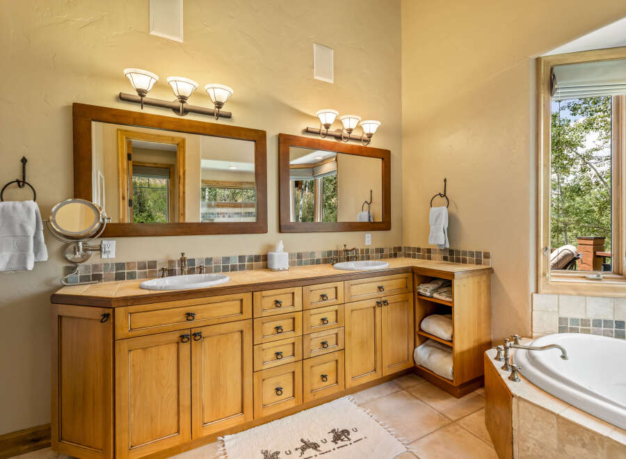 This luxurious bathroom features a spacious double vanity with ample storage and elegant wood cabinetry.