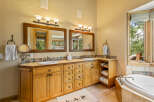 This luxurious bathroom features a spacious double vanity with ample storage and elegant wood cabinetry.