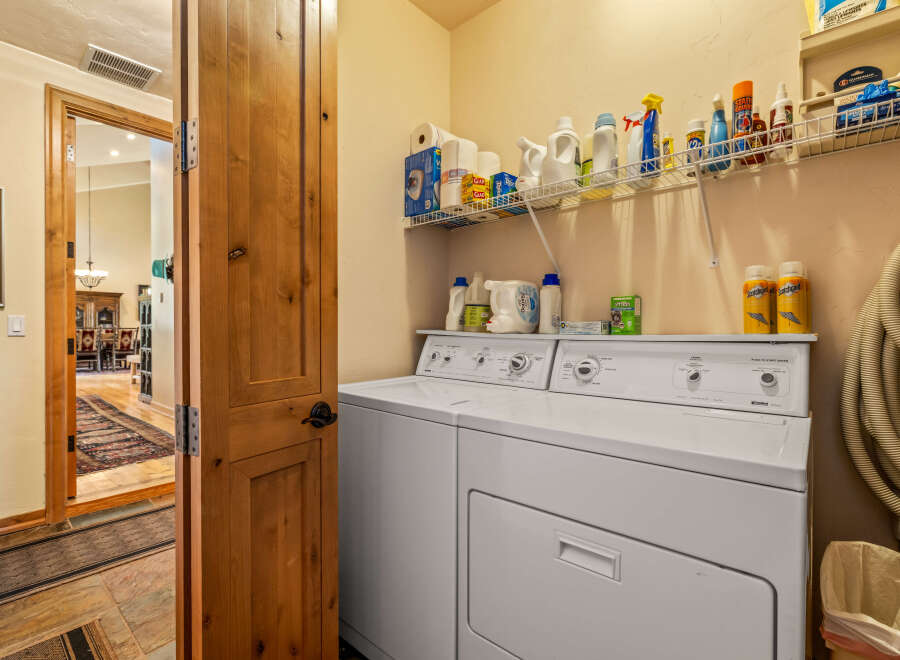 This laundry room features a spacious white washer and dryer set, perfect for handling large loads.