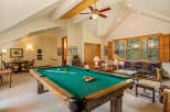 Enjoy endless entertainment in this spacious game room, featuring a full-size pool table and a cozy seating area.